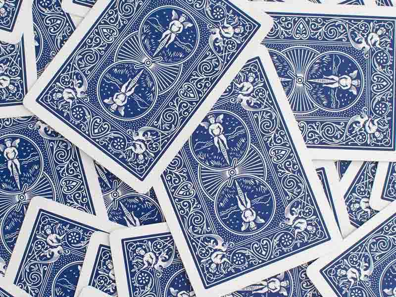Pile of blue playings cards scattered on a surface 