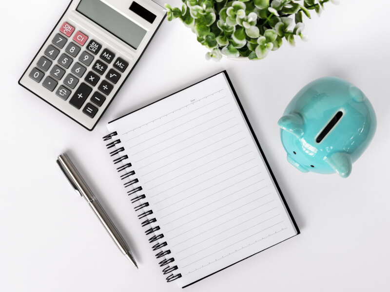 image showing office supplies, a plant and a piggybank