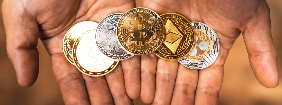 person holding physical cryptocurrencies in their hands