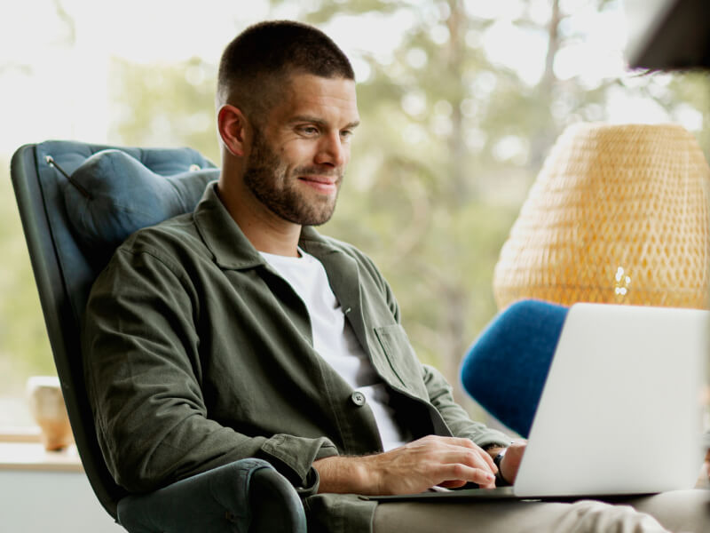 Man smiling while working on his laptop