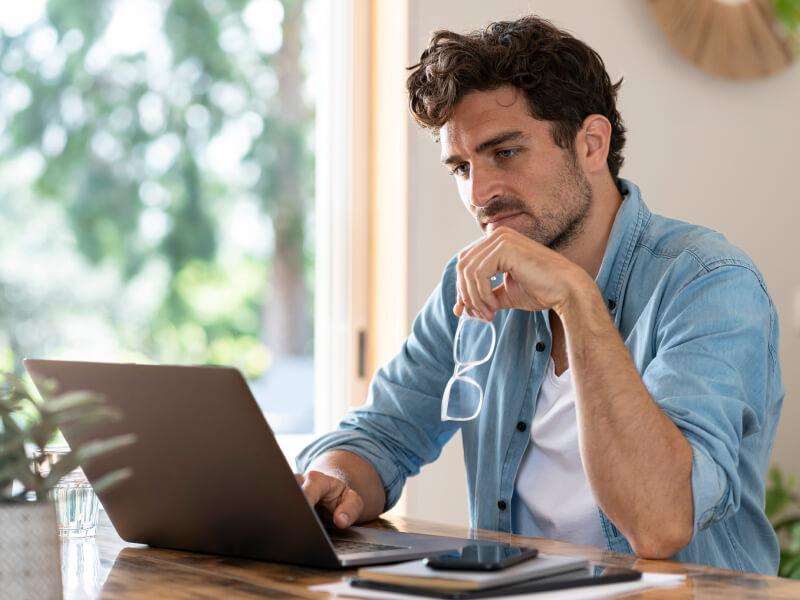 Man looking at his laptop in thought