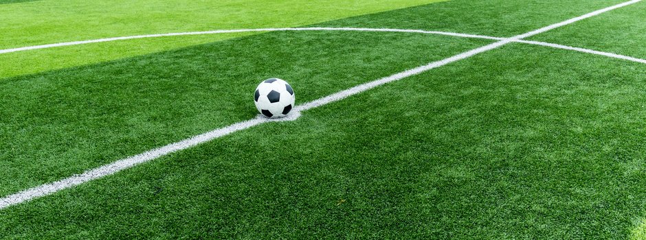 soccer field grass with ball at kick off point