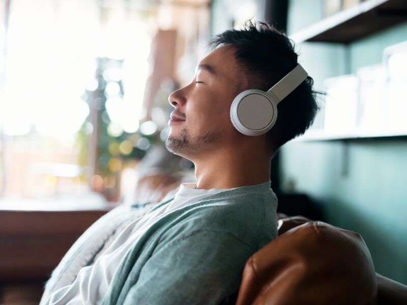 man with headphones smiling with eyes closed