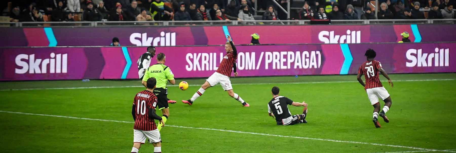 AC Milan playing on the field; Skrill ads in the background