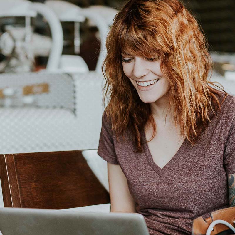smiling woman looking at a laptop