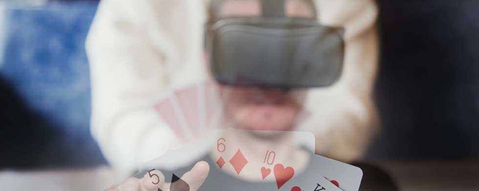 Man wearing VR glasses and holding cards