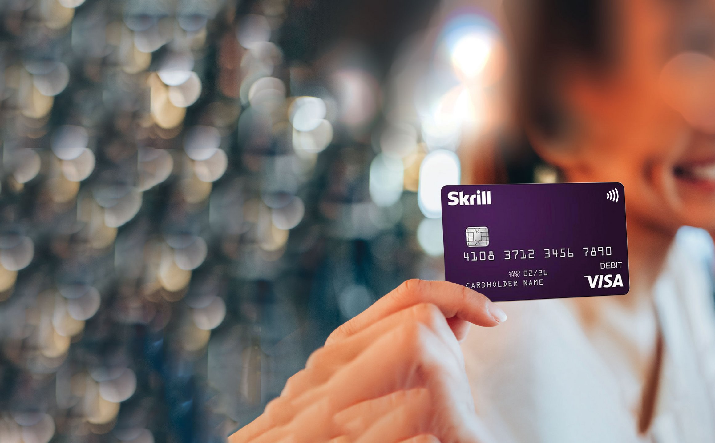 smiling girl holds a Skrill Visa card